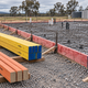 RedEdge LVL installed around a reinforced slab with thin orange NelsonPine NP Form and Yellow Edge LVL stored beside the formwork