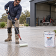 Tradesperson applying sealer to new exposed aggregate concrete with Auseal Curite sealer, lambswool roller and Masterfinish sprayer